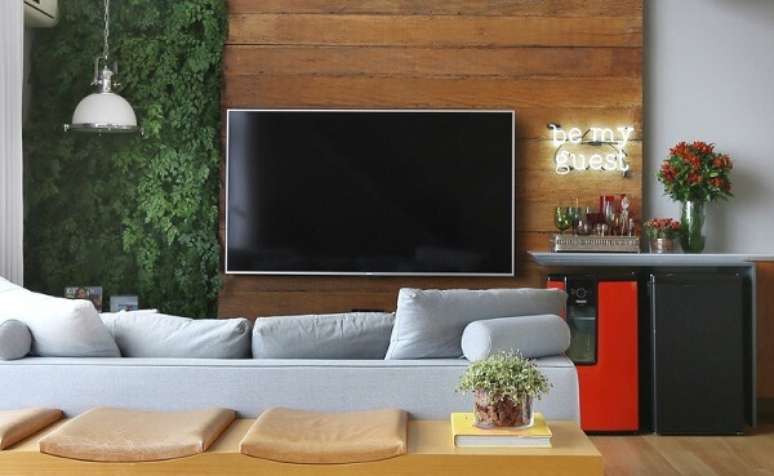 42- As plantas para sala artificiais formam o jardim vertical no painel da TV. Fonte: Pinterest