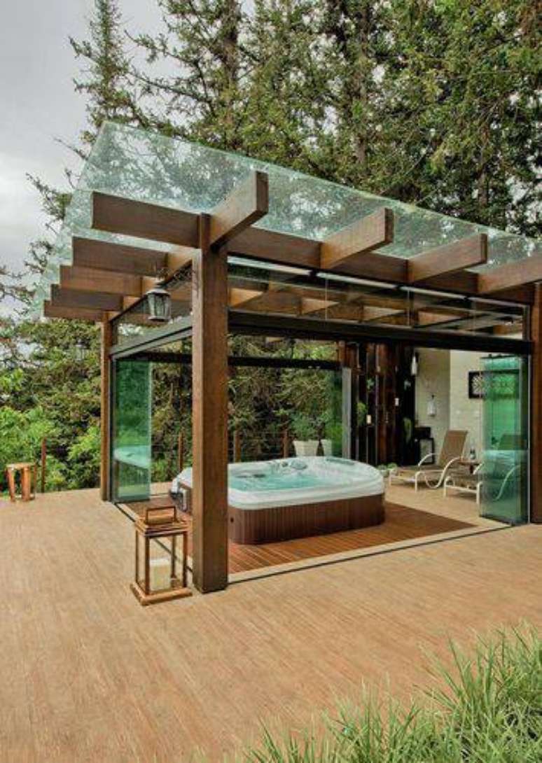 28. Para proteger sua banheira de hidromassagem, você pode cobrir o pergolado de madeira com uma placa de vidro