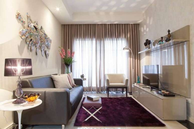 62- O tapete roxo garante um ambiente mais confortável para a sala em tons neutros