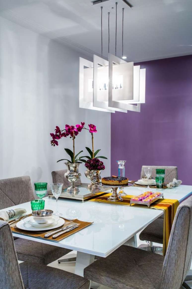 27- As cores de parede roxas na sala de jantar remetem à elegância. Projeto de Milla Holtz.
