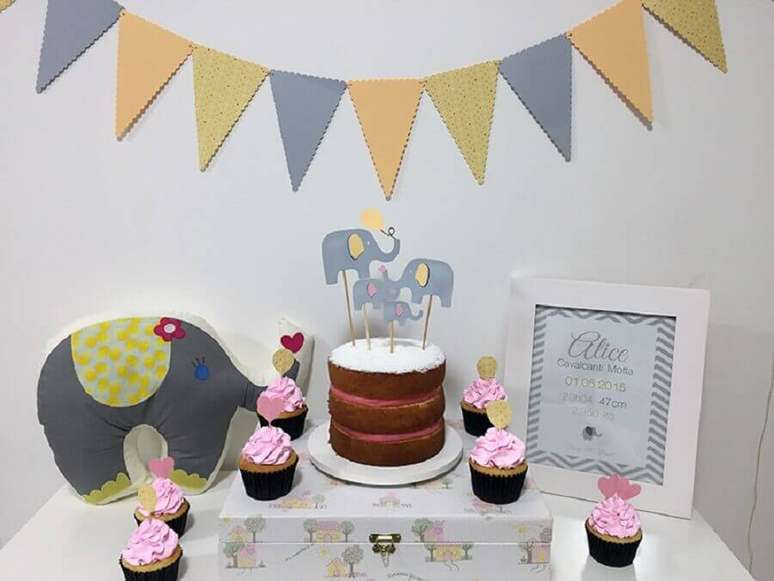 56. Mesversário simples decorado com elefantinho e varal de bandeirinhas – Foto: iBabysite