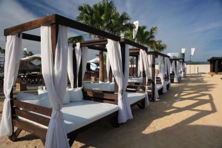 74. M&oacute;vel de praia com pergolado de madeira com cortina &ndash; Foto: Marchetti Bonetti