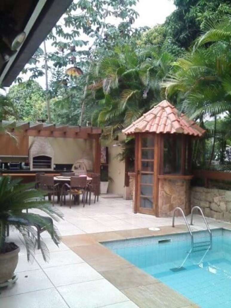 100. Pergolado de madeira para &aacute;rea externa com churrasqueira e piscina &ndash; Foto: Margareth Salles