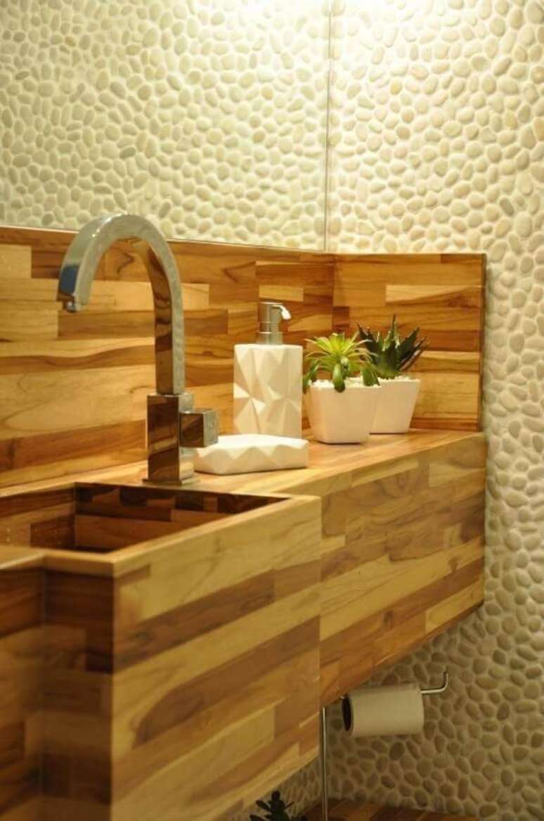 47. Aqui a cuba de madeira para lavabo se tornou o grande destaque na decoração com parede revestida de pedra – Foto: Piso em Madeira
