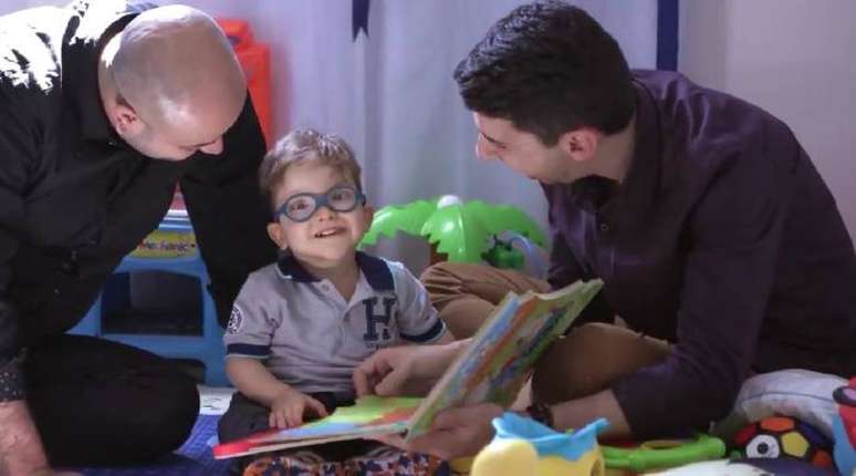 Diego e Leandro brincando com o filho na Associação de Assistência à Criança com Deficiência (AACD), onde menino recebe cuidados médicos.
