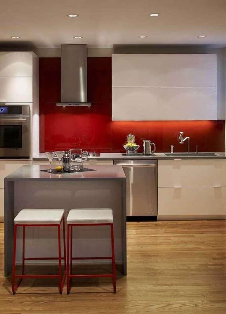 7. Decoração moderna para cozinha vermelha com piso de madeira e ilha cinza – Foto: Pinosy