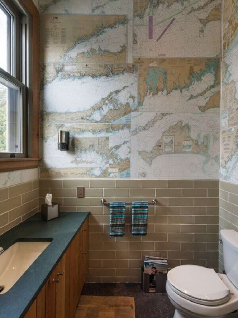 9- O papel de parede para lavabo estampado com mapas é igual às lajotas que revestem meia parede. Fonte: Carro de Mola
