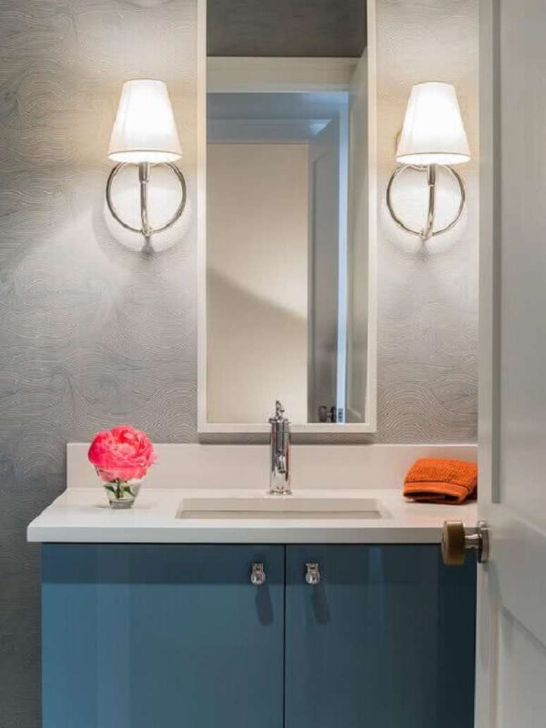 26- O papel de parede para lavabo em tom cinza combina com o armário da bancada azul. Fonte: Pinterest