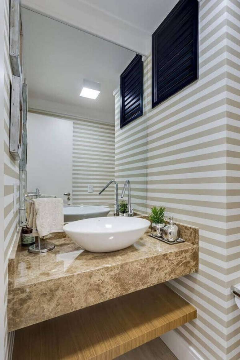 58- O papel de parede para lavabo listrado em branco e bege combina com a bancada em mármore travertino. Fonte: Pinterest