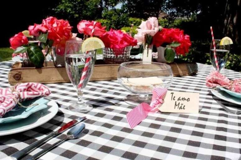 41- A decoração dia das mães em área descoberta tem toalha de mesa xadrez e bandeja rústica com flores. Fonte: ConstruindoDecor