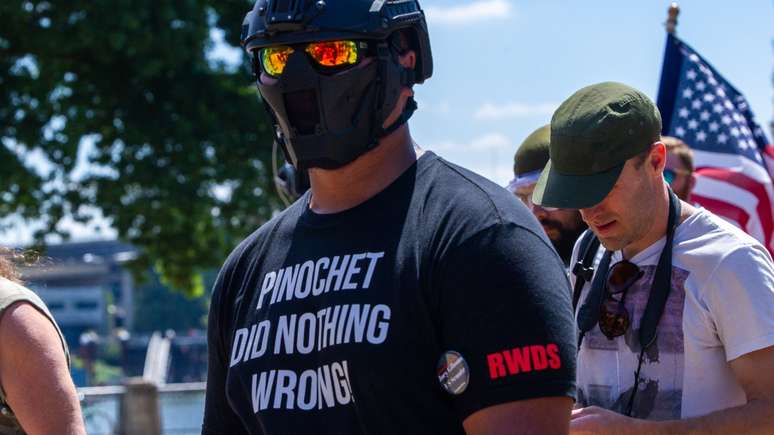 'Tiny' Toese em protesto em Portland; "RWDS", na manga da camisa, que dizer "Right wing death squad" - "Esquadr&atilde;o da morte de direita"