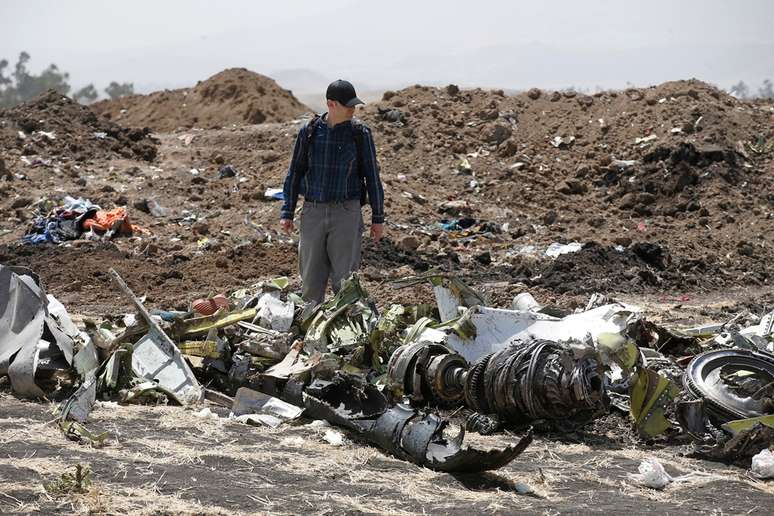 Homem caminha em meio aos destroços do avião da Ethiopian Airlines