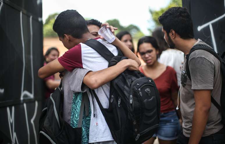 Estudantes e pais de alunos se emocionam ao se reencontrarem em frente ao portão da Escola Estadual Professor Raul Brasil, em Suzano, na Grande São Paulo, após o massacre