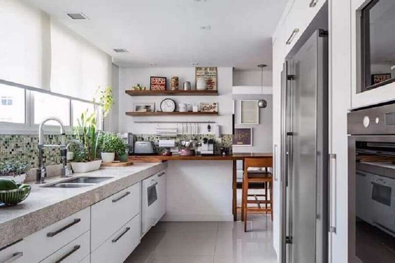 47. Decoração para cozinha com granito na bancada e prateleiras de madeira – Foto: Alvorada Arquitetura