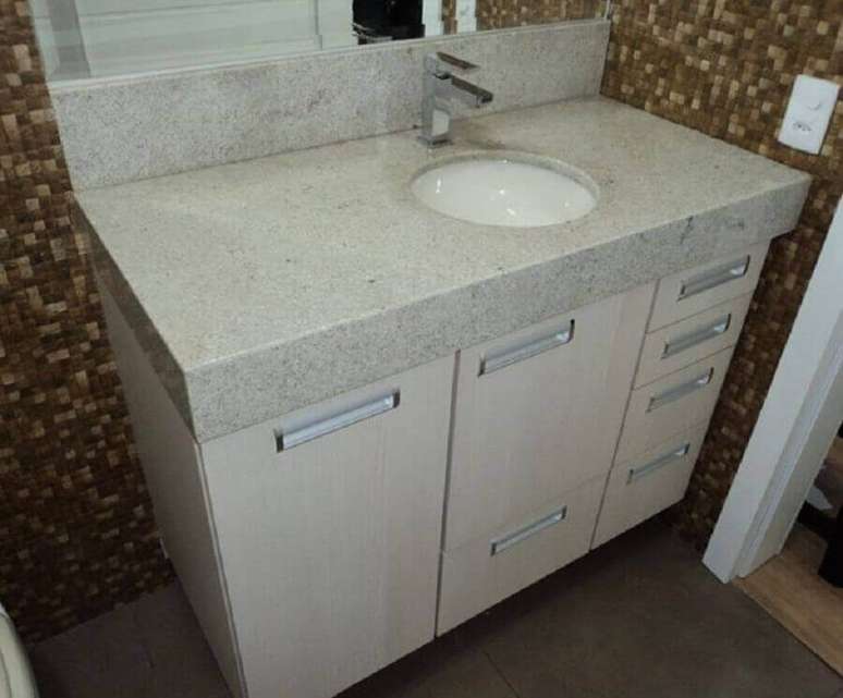 52. Granito branco Itaúnas para banheiro simples decorado com revestimento de pastilhas marrons – Foto: Grupo Comelli