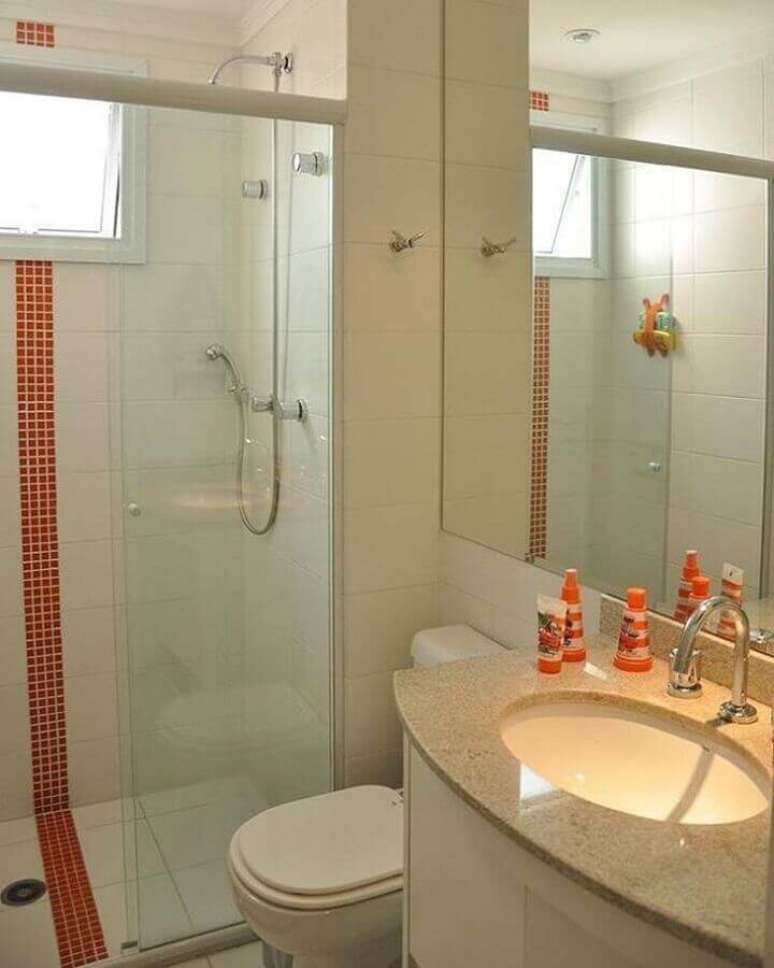 55. Decoração com granito branco marfim para banheiro com faixa de pastilha laranja – Foto: Marmorir Mármores e Granitos