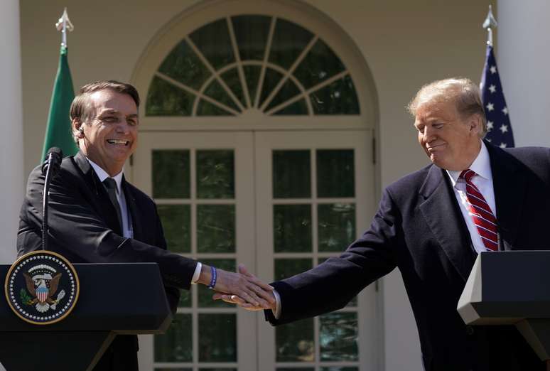 Presidentes Jair Bolsonaro e Donald Trump se cumprimentam nos jardins da Casa Branca