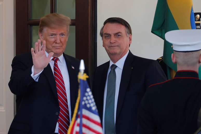 Presidente dos EUA, Donald Trump, acena ao lado de do presidente brasileiro Jair Bolsonaro em encontro realizado na Casa Branca