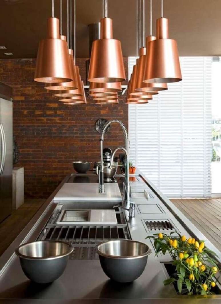 33. Decoração em cobre para cozinha moderna com parede de tijolinho e várias luminárias pendentes – Foto: Blog da Tetê