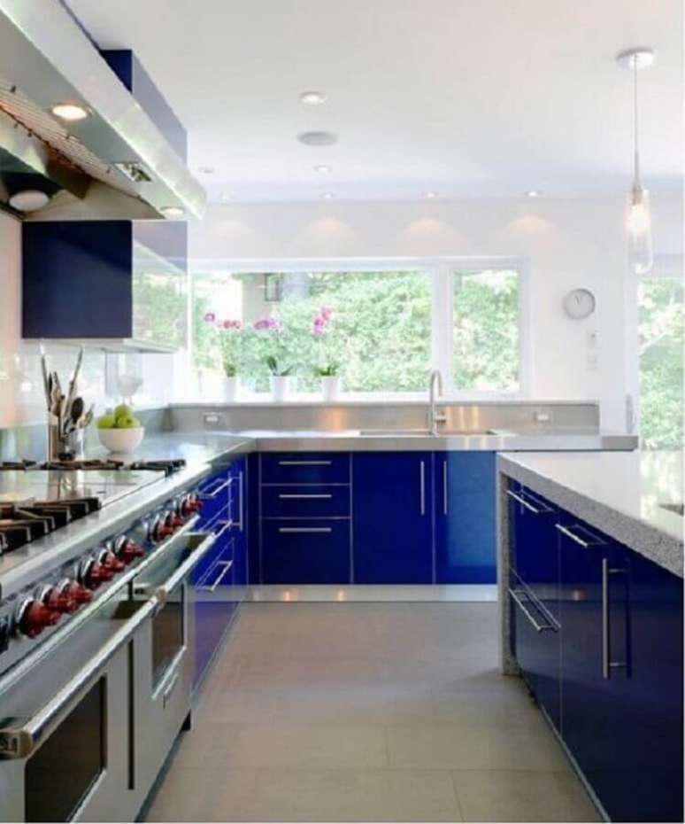 39. Cozinha planejada ampla decorada com armário azul royal e luminária pendente – Foto: Wisma Home