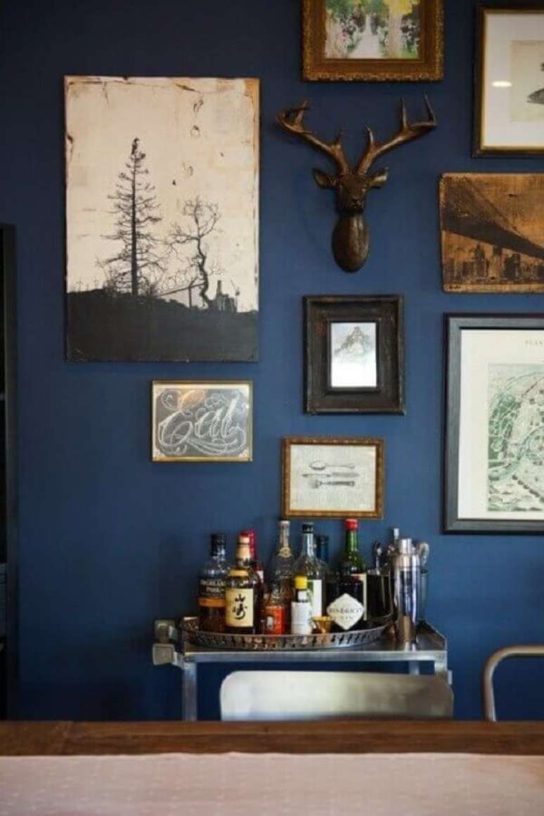 53. Decoração com parede azul e vários quadros – Foto: Pinterest