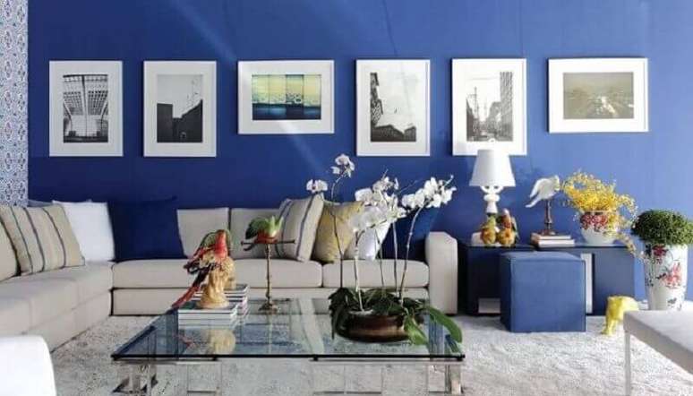 48. Decoração azul royal para sala com sofá branco e quadros na parede – Foto: MMPM