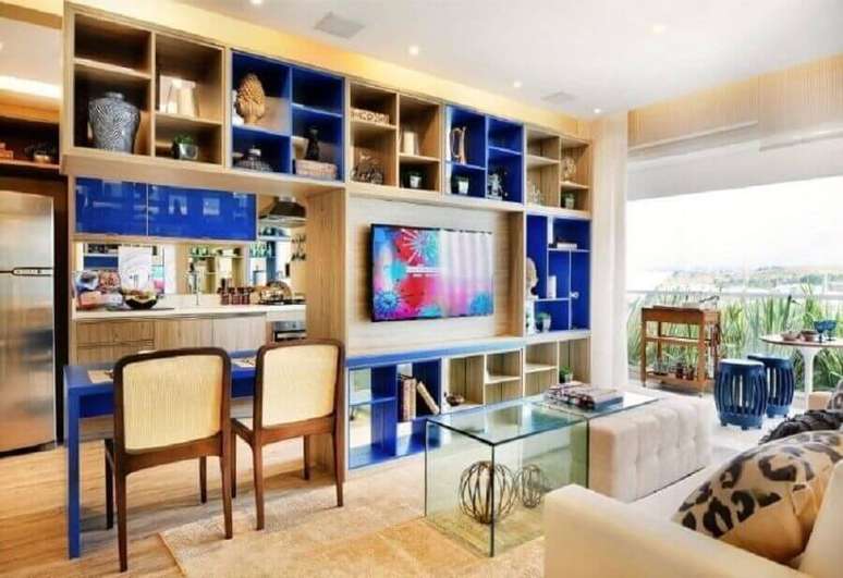 71. Decoração para sala de estar ampla com estante de madeira com módulos azuis royais – Foto: Quitete Faria