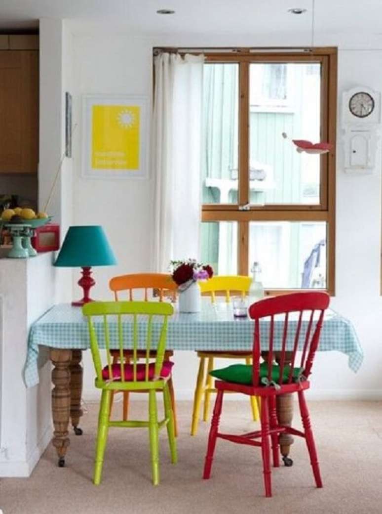 31- A decoração de sala simples e barata de jantar tem mesa em madeira natural e cadeiras coloridas. Fonte: Pinterest