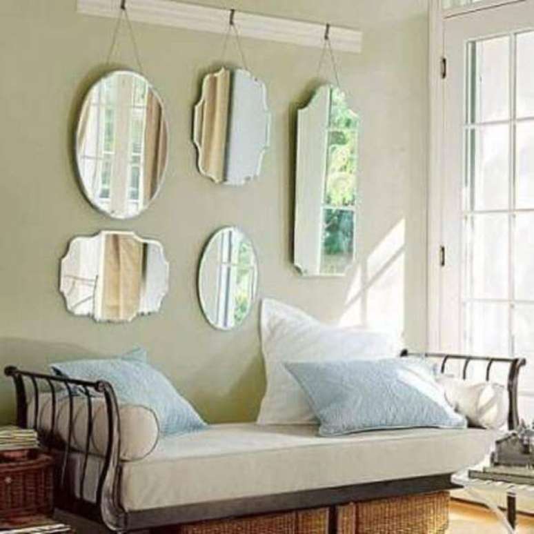 23- A decoração de sala simples e barata conta com espelhos em estilo clássico pendurados na parede atrás do sofá. Fonte: Decoração de Casa
