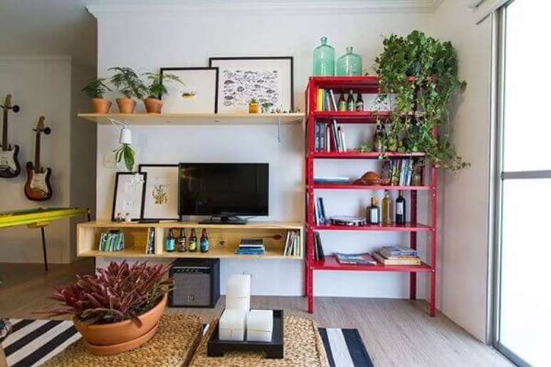 25- Na decoração de sala simples e barata, a estante vermelha de metal é um dos principais destaques do ambiente. Fonte: Web Comunica