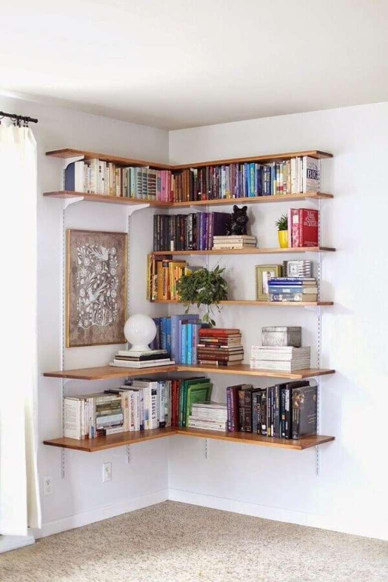 26- Na decoração de sala simples e barata, o canto tem estante com trilhos como biblioteca. Fonte: Pinterest