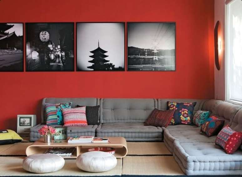 58- Na decoração de sala simples e barata em estilo oriental conta com futons cinza, paredes vermelhas e tapete com esteiras. Fonte: Pinterest