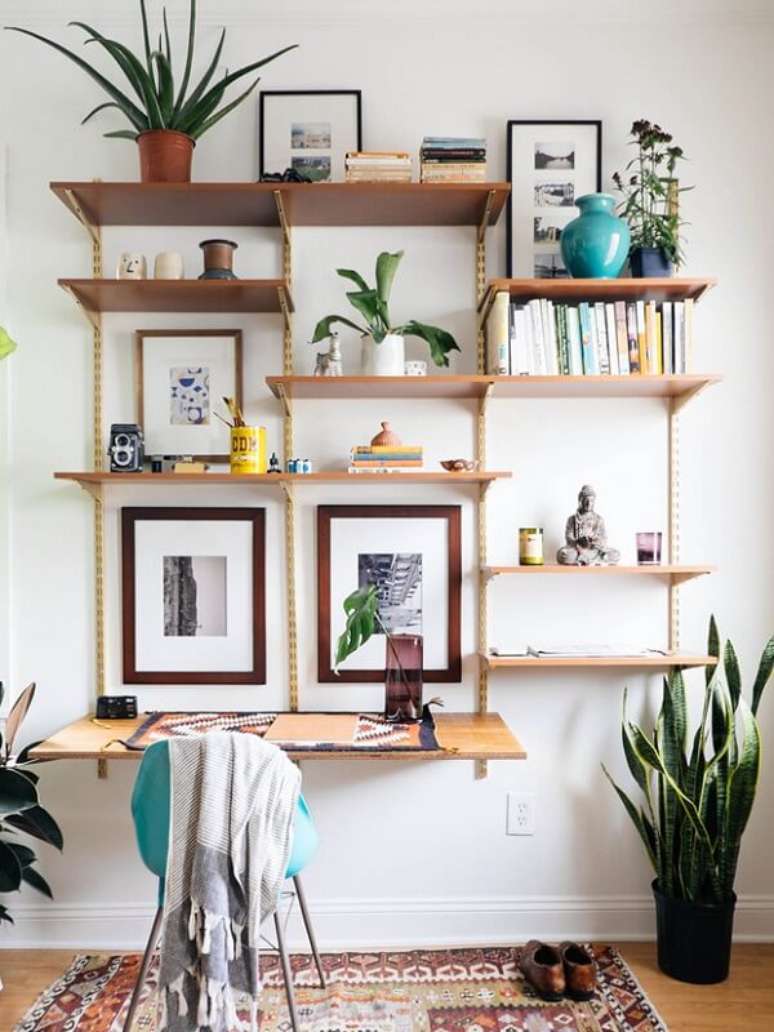 60- Na decoração de sala simples e barata, a estante com trilhos tem a função de escrivaninha. Fonte: Revista Glamour
