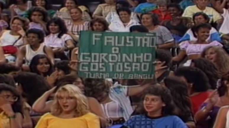 F&atilde; leva cartaz &agrave; plateia do primeiro 'Doming&atilde;o do Faust&atilde;o'.