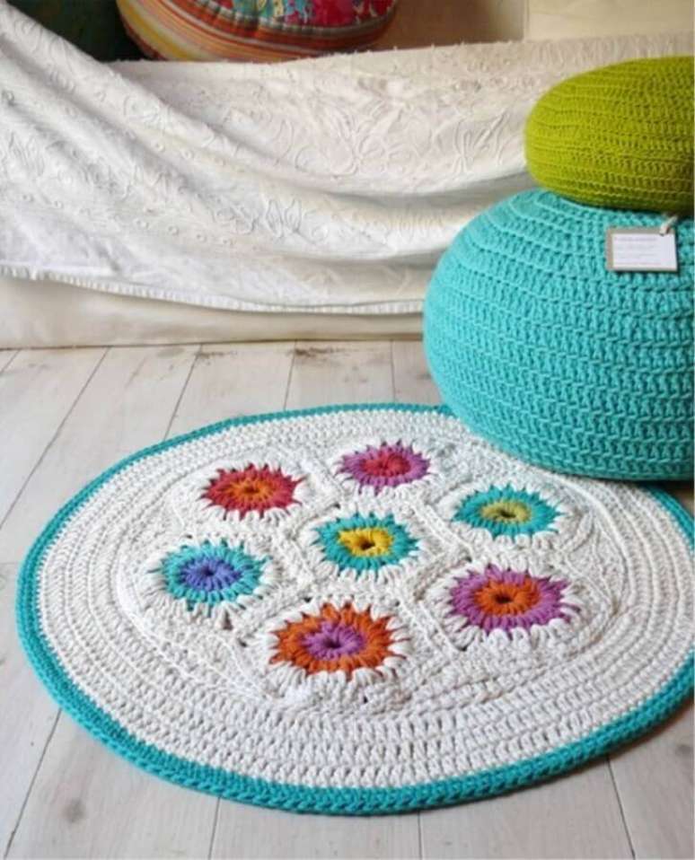 99. Modelo simples de tapete de croch&ecirc; com flores coloridas e acabamento em azul na lateral &ndash; Foto: Etsy