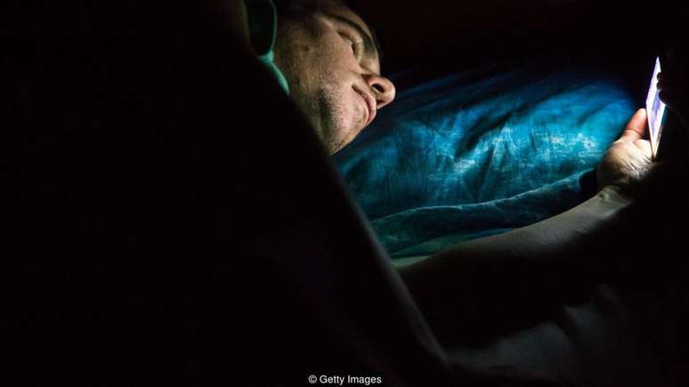Usar o celular na cama antes de dormir pode causar problemas de sono