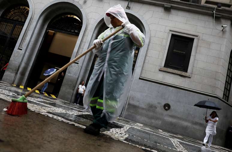 Homem limpa rua na frente do prédio da B3, em São Paulo. 21/3/2019. REUTERS/Nacho Doce 