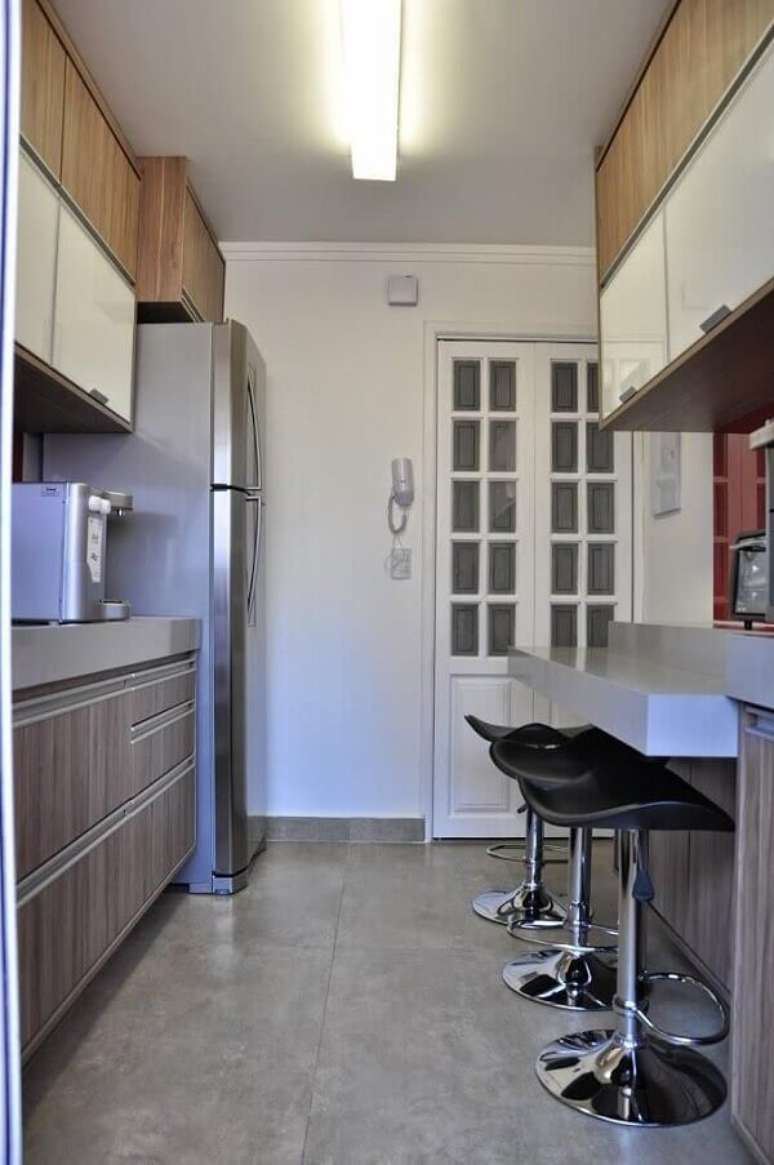 11- A decora&ccedil;&atilde;o para casa pequena, a bancada da cozinha serve de mesa e divis&oacute;ria de ambientes. Fonte: Serra Vaz Arquitetura