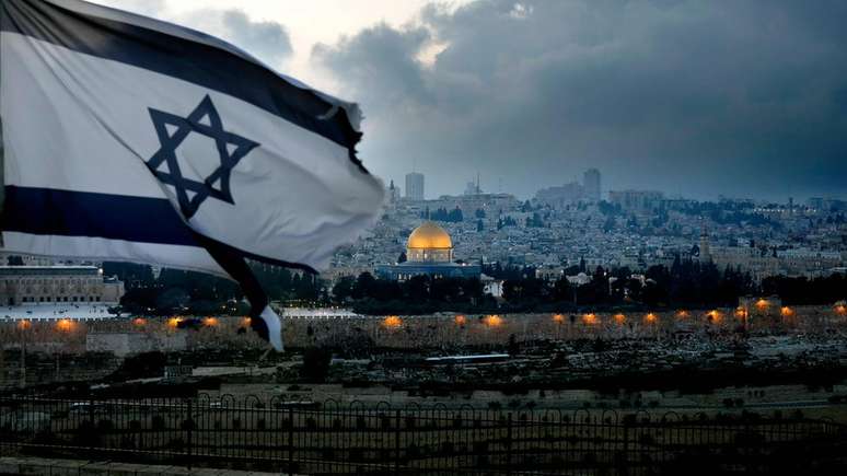 Bandeira de Israel tremula no Monte das Oliveiras com a Cidade Velha de Jerusalém ao fundo