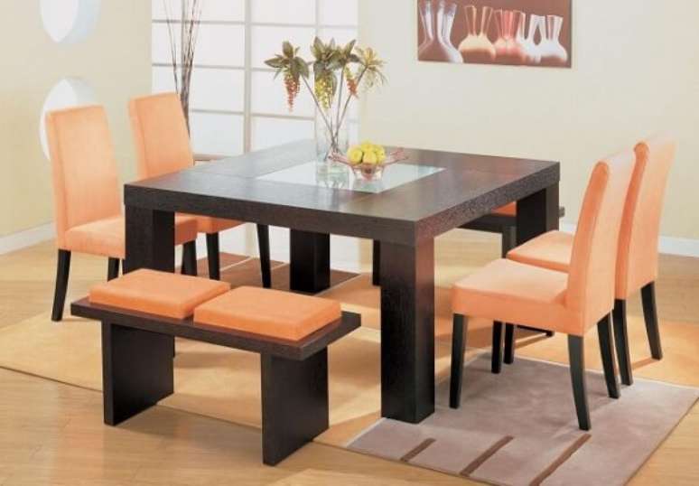 48- Na sala de jantar, a mesa, banquetas e pernas das cadeiras são pretas e os estofados são da cor salmão. Fonte: Urban Glamourous