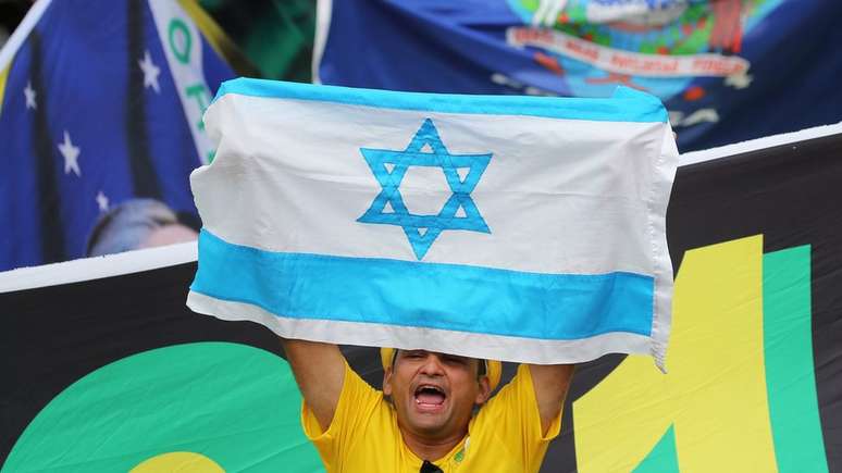 Homem levanta bandeira de Israel durante posse de Bolsonaro em Brasília; presidente prometeu, durante campanha, transferência de embaixada para Jerusalém