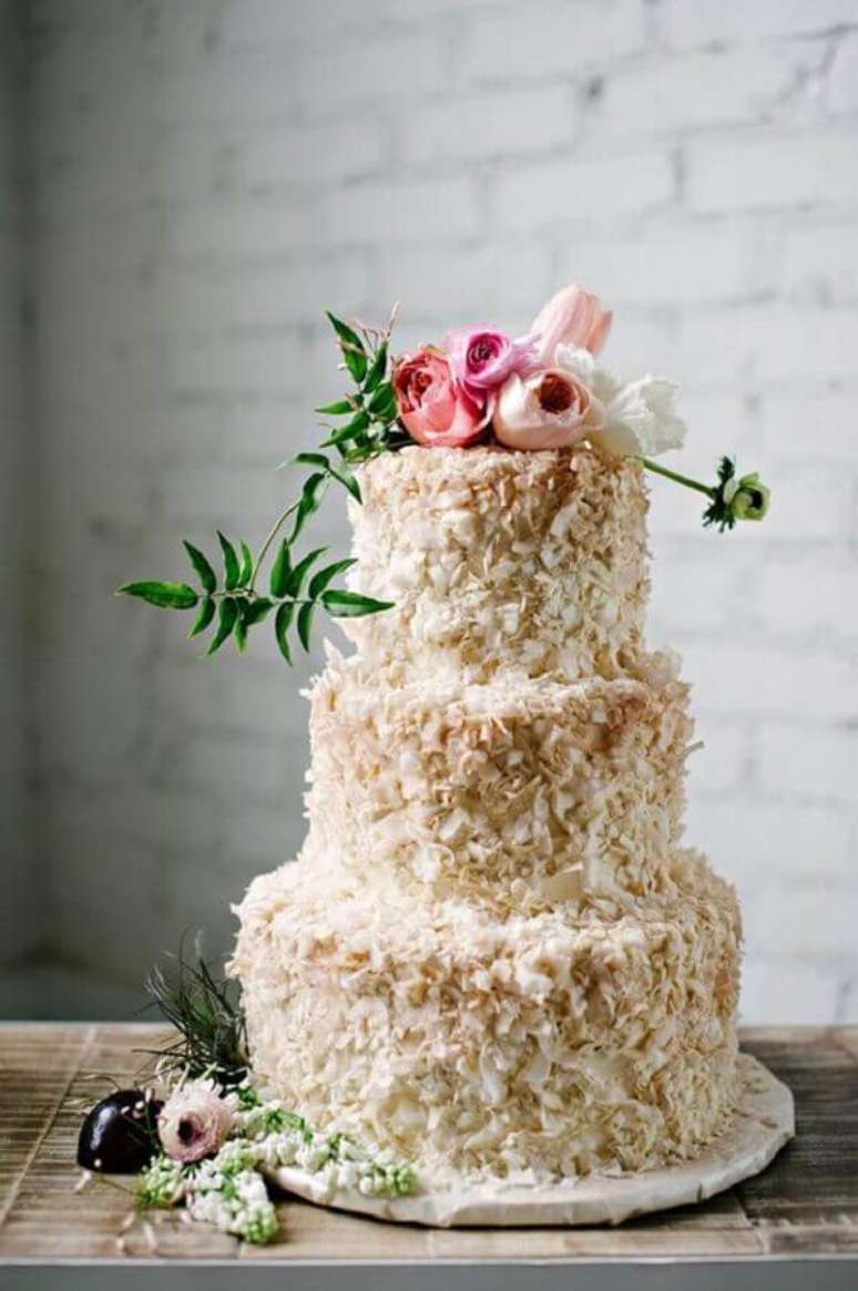 33. Lindo bolo decorado com flores e coco – Foto: WeddingOMania