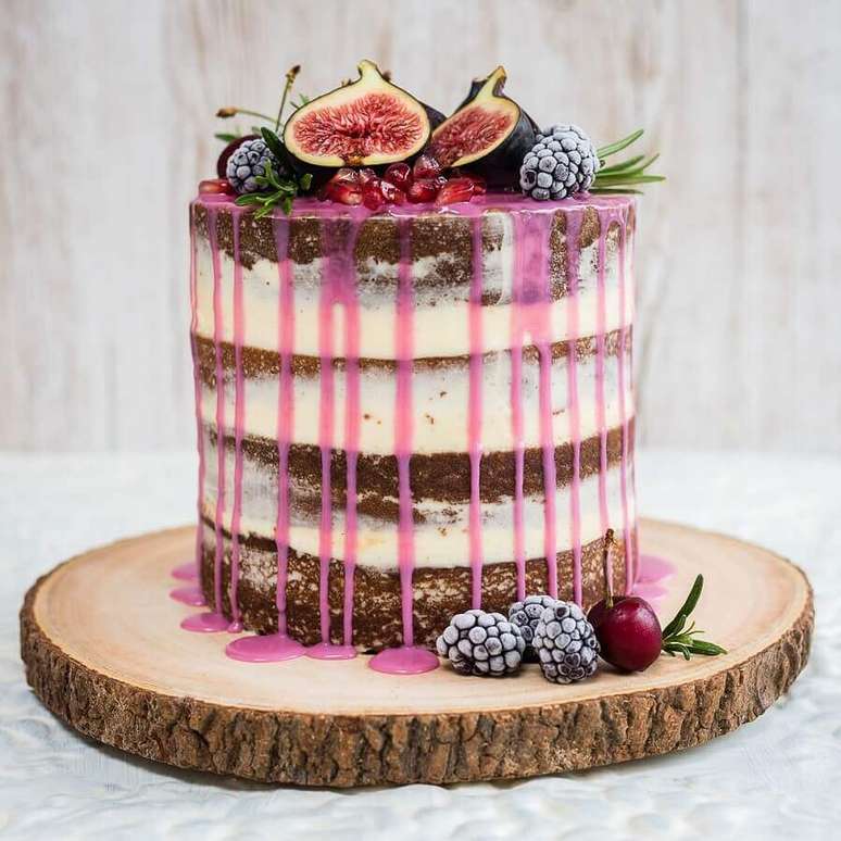 37. Bolo decorado com frutas e calda cor de rosa para uma festa rústica – Foto: PS do Vidro