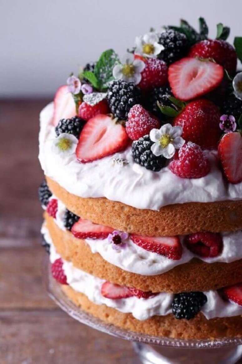 41. Bolo decorado com frutas vermelhas e pequenas flores brancas estilo naked cake – Foto: Pinterest