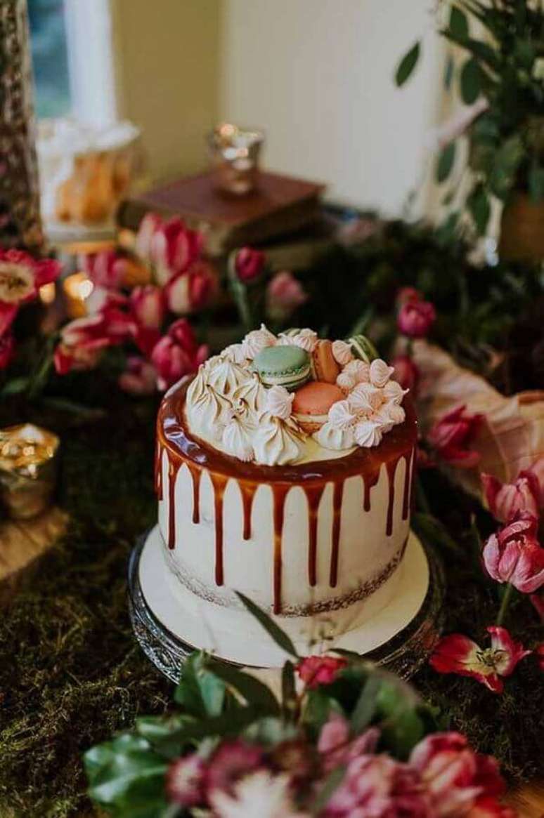 69.. Decoração de bolo com calda de chocolate, suspiros e macarons no topo – Foto: 100 Layer Cake