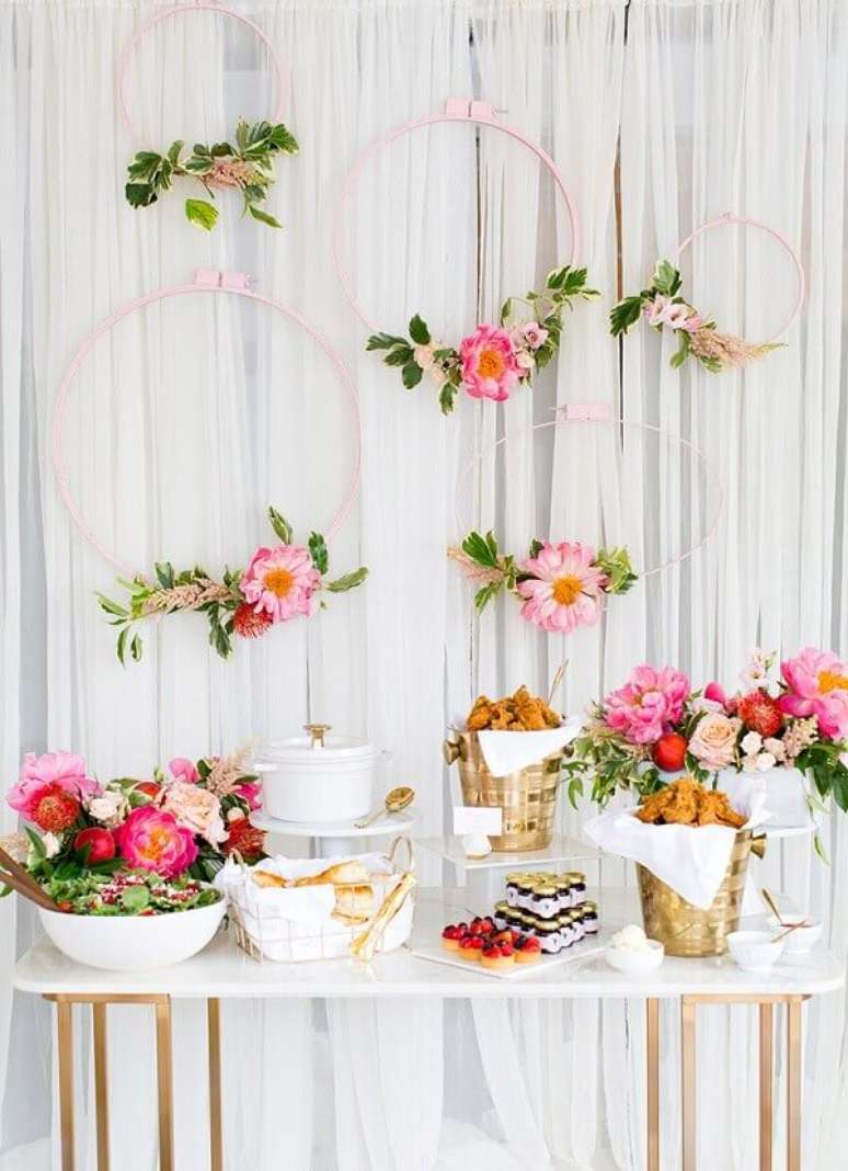 25- A mesa do chá de casa nova foi colocada próxima à cortina enfeitada com arcos rosa e flores. Fonte: Revista Icasei