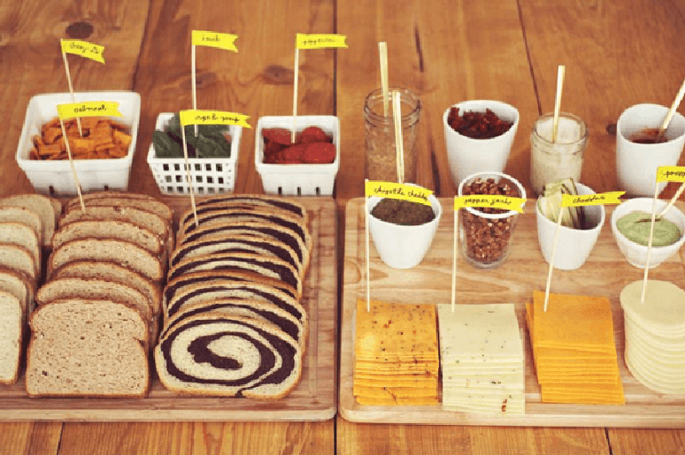 34- No chá de casa nova, os salgadinhos, pães e queijos têm bandeirinhas com o nome dos produtos. Fonte: Beautiful Mess