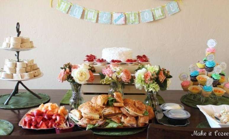 45- No chá de casa nova, a mesa tem vasos de flores em tons suaves e delicados. Fonte: Make It cozee