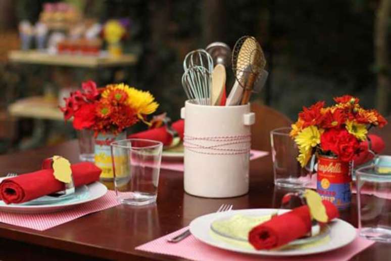 48- Na mesa do chá de casa nova, as latas de produtos alimentícios viram vaso para flores coloridas. Fonte: Vestidos de Noiva