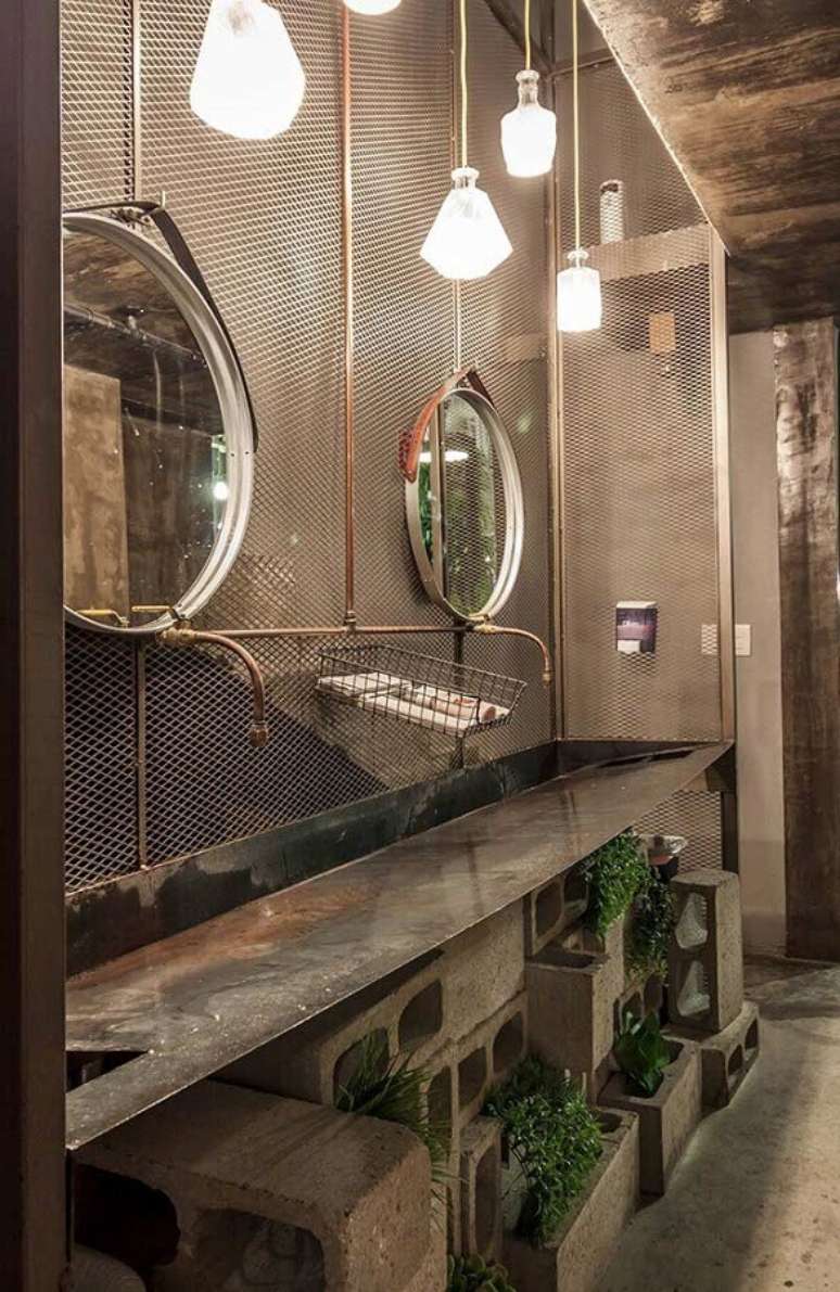 28.. Decoração com estilo industrial para banheiro masculino com blocos de concreto e espelho redondo – Foto: Pinterest